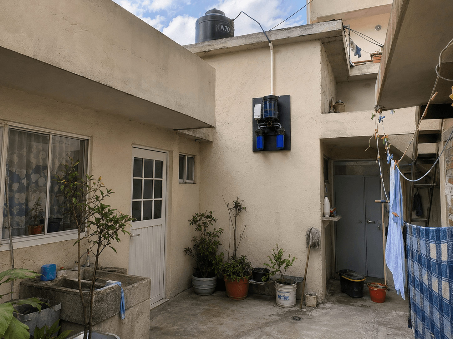 Sistema ¡HayAgua! H20 instalado en el muro de un patio doméstico en Ciudad de México, conectado a la bajante y al tinaco.